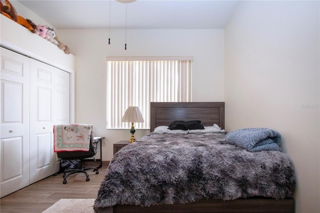 bedroom with light hardwood / wood-style floors and a closet