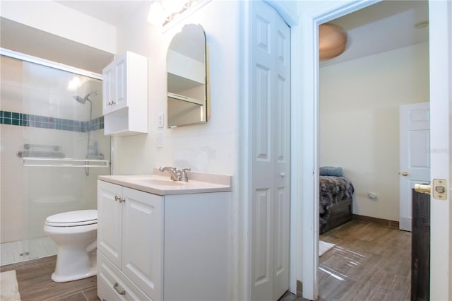 bathroom with toilet, an enclosed shower, and vanity