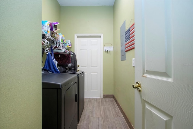 clothes washing area with washer and dryer and light hardwood / wood-style floors