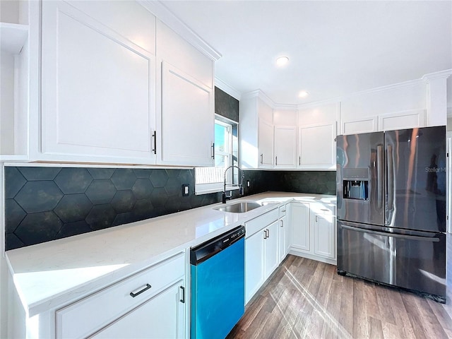 kitchen with backsplash, sink, light stone countertops, white cabinetry, and stainless steel appliances