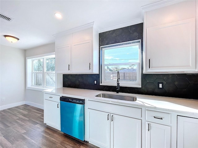 kitchen featuring dishwasher, sink, tasteful backsplash, wood-type flooring, and white cabinets