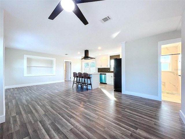 unfurnished living room with built in shelves, dark hardwood / wood-style flooring, and plenty of natural light