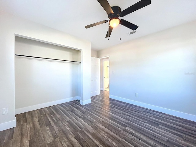 unfurnished bedroom with ceiling fan, dark hardwood / wood-style flooring, and a closet