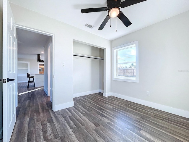 unfurnished bedroom featuring ceiling fan, dark wood-type flooring, and a closet