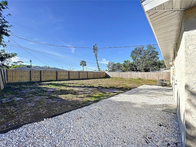 view of yard with central AC unit and a patio