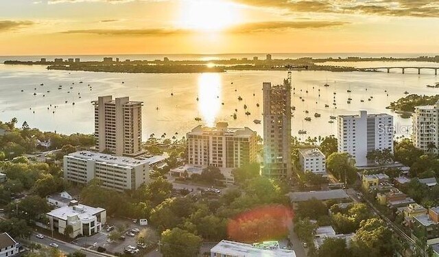 aerial view at dusk featuring a water view