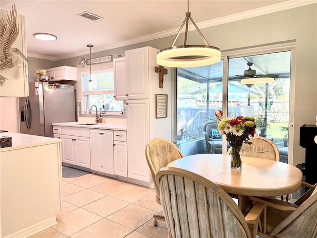 dining room with crown molding, sink, and light tile patterned floors