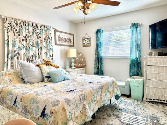 bedroom with ceiling fan and a textured ceiling