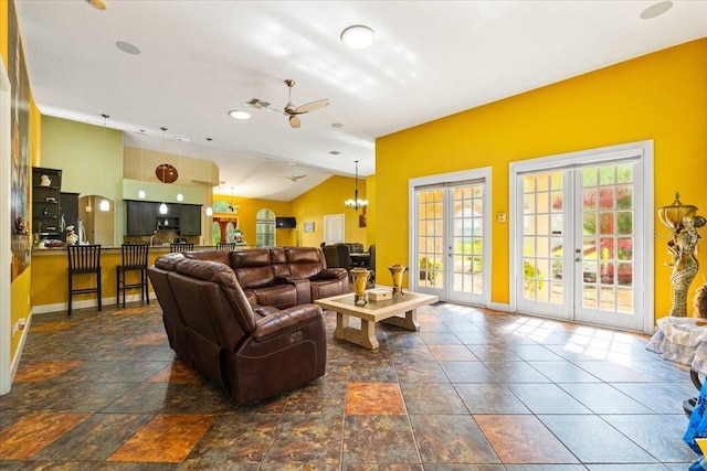 living room featuring vaulted ceiling, french doors, and ceiling fan with notable chandelier