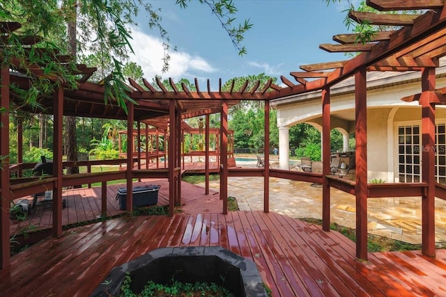 wooden terrace featuring a pergola and an outdoor fire pit