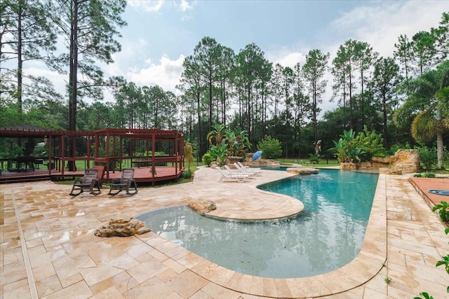 view of pool with a wooden deck and a patio