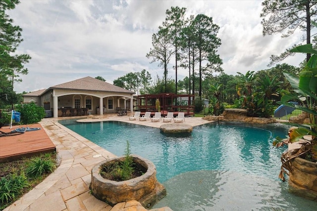 view of pool featuring a patio and a wooden deck