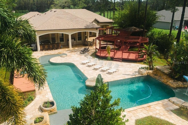 view of pool with a bar and a wooden deck