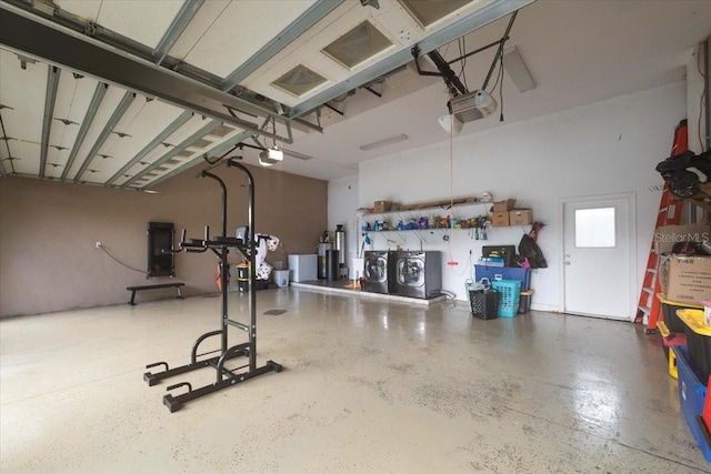 garage featuring independent washer and dryer and a garage door opener