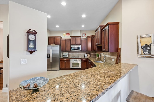 kitchen with light stone countertops, tasteful backsplash, stainless steel appliances, sink, and light tile patterned floors