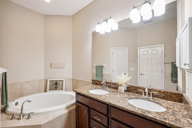 bathroom featuring vanity and a relaxing tiled tub