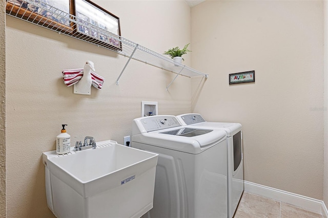 laundry area with separate washer and dryer and sink