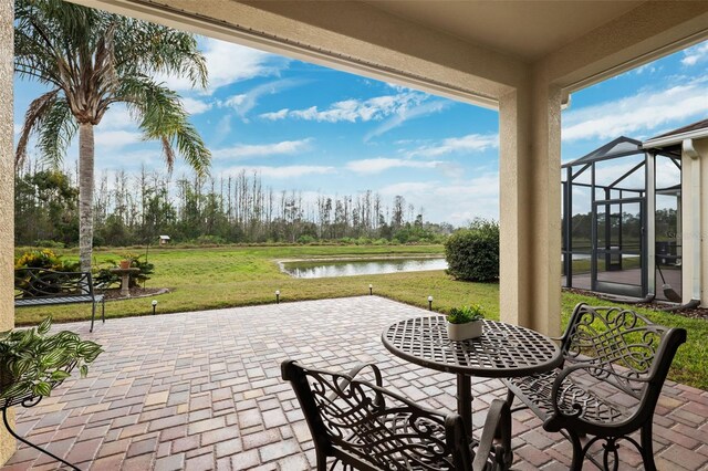 view of patio with glass enclosure and a water view