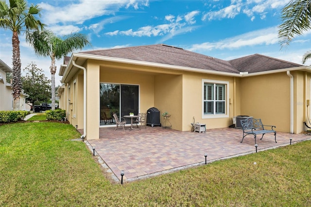 rear view of property featuring a yard and a patio area