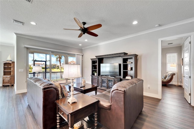 living room with ceiling fan, ornamental molding, a textured ceiling, and dark hardwood / wood-style floors