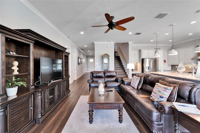 living room featuring a textured ceiling, crown molding, and dark hardwood / wood-style flooring