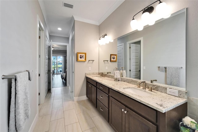 bathroom with ornamental molding and vanity