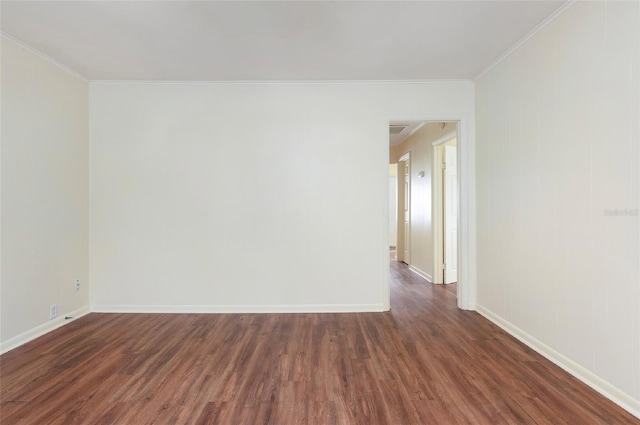 empty room with ornamental molding and dark hardwood / wood-style flooring