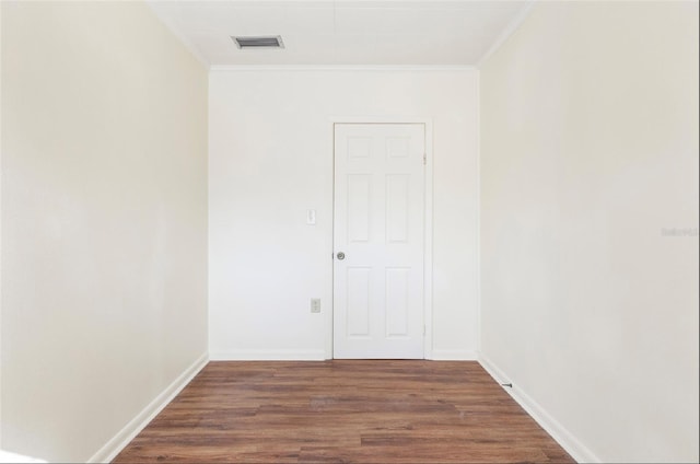 spare room featuring crown molding and dark hardwood / wood-style flooring