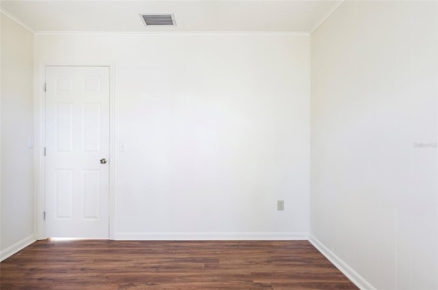 empty room with ornamental molding and dark hardwood / wood-style floors