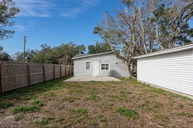 back of property with a lawn and a patio area