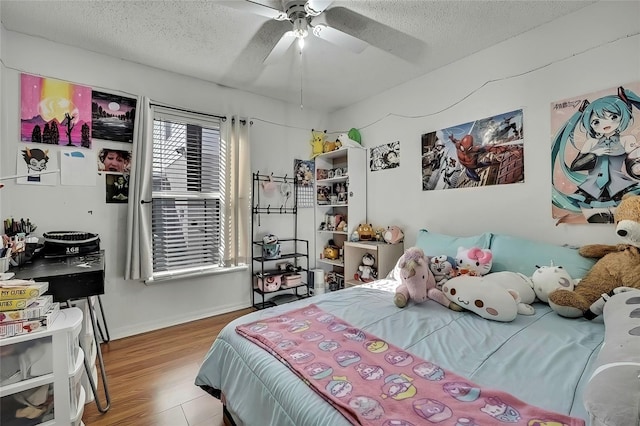 bedroom with a textured ceiling, ceiling fan, and hardwood / wood-style flooring