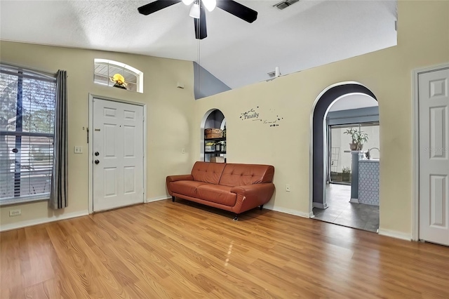 entryway featuring lofted ceiling, a textured ceiling, light wood-type flooring, and ceiling fan