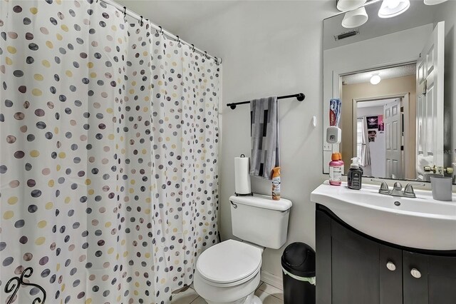 bathroom featuring toilet, vanity, and tile patterned floors