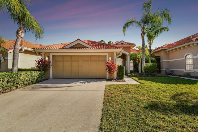 mediterranean / spanish-style home with a yard and a garage