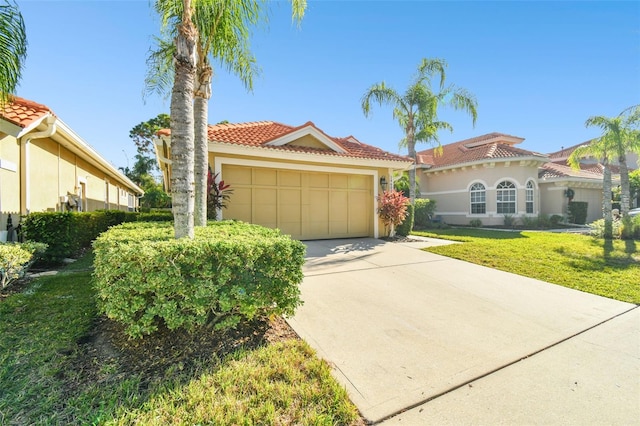 mediterranean / spanish home featuring a front yard and a garage