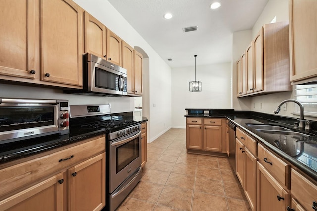 kitchen with pendant lighting, light tile patterned floors, sink, and appliances with stainless steel finishes