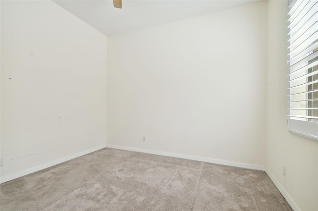 carpeted spare room featuring ceiling fan