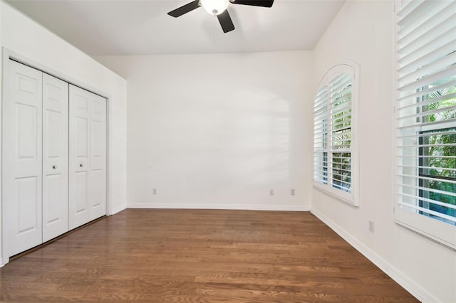 unfurnished bedroom with multiple windows, dark hardwood / wood-style floors, and ceiling fan