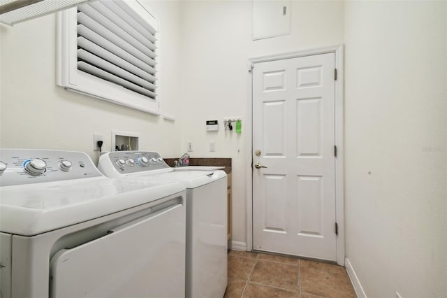 laundry area with separate washer and dryer, sink, and light tile patterned floors