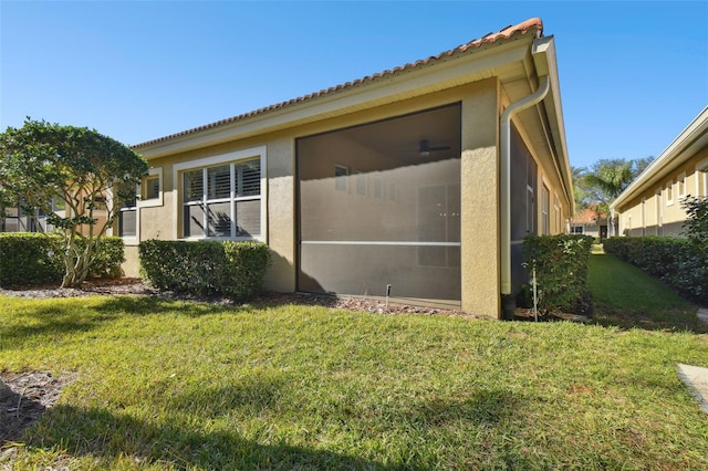 view of home's exterior with a lawn and a sunroom