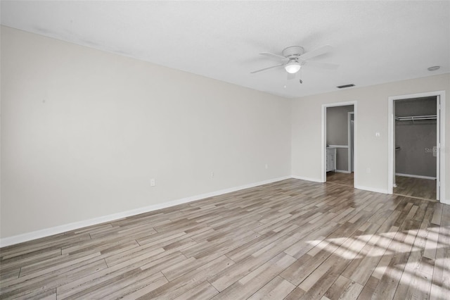 unfurnished bedroom featuring a closet, visible vents, baseboards, and wood finished floors