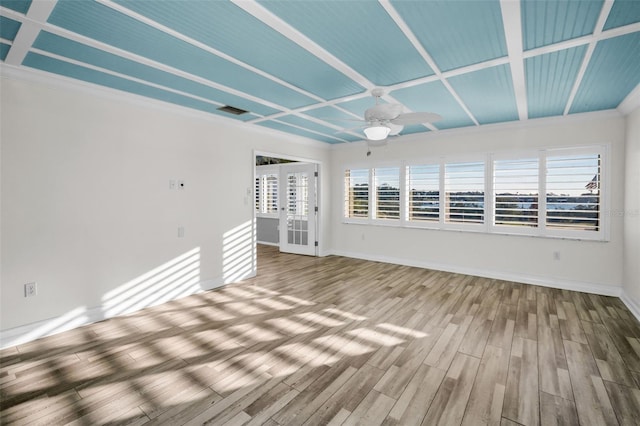 empty room with ceiling fan, french doors, plenty of natural light, and wood finished floors