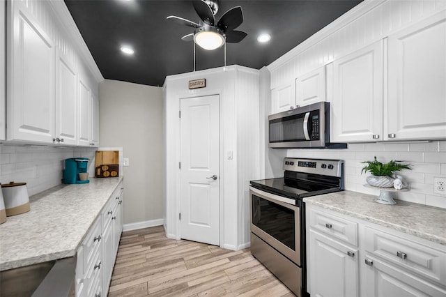 kitchen featuring light countertops, appliances with stainless steel finishes, light wood-style flooring, and white cabinets