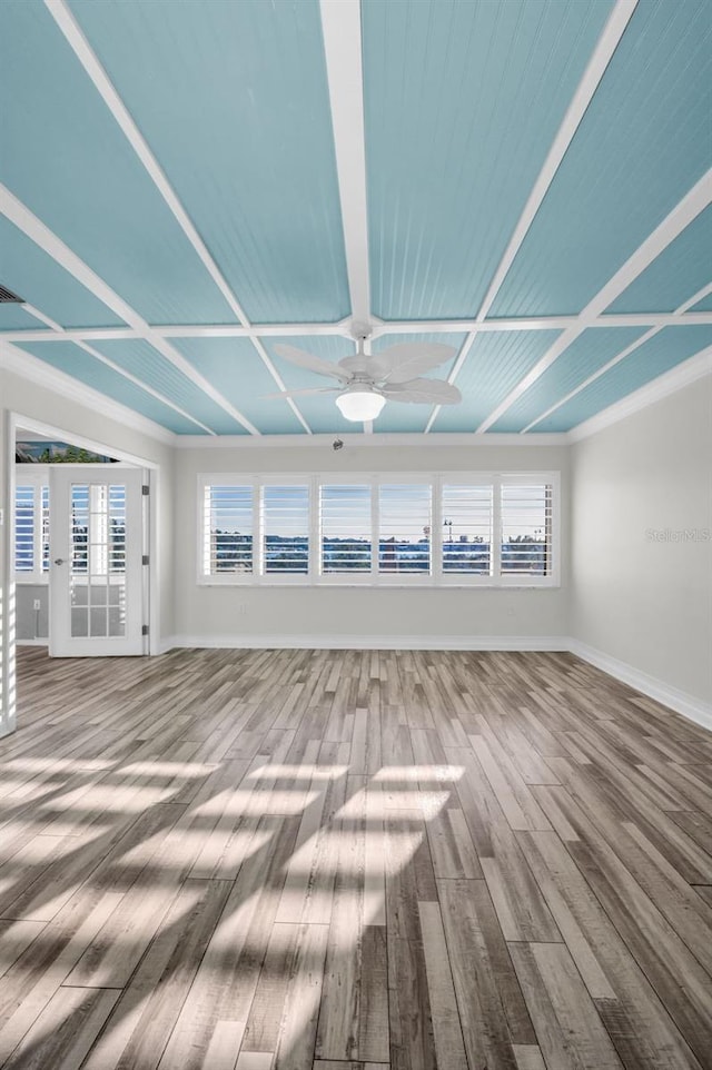 unfurnished living room featuring wood finished floors, a ceiling fan, and baseboards