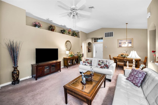 carpeted living room with ceiling fan with notable chandelier and lofted ceiling