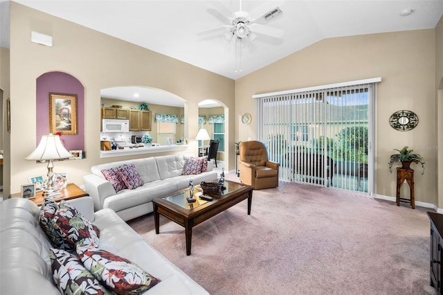 carpeted living room with ceiling fan and vaulted ceiling