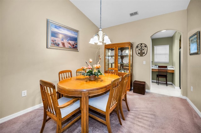 carpeted dining area featuring vaulted ceiling and an inviting chandelier