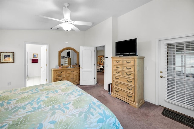 carpeted bedroom featuring ceiling fan, ensuite bathroom, and vaulted ceiling