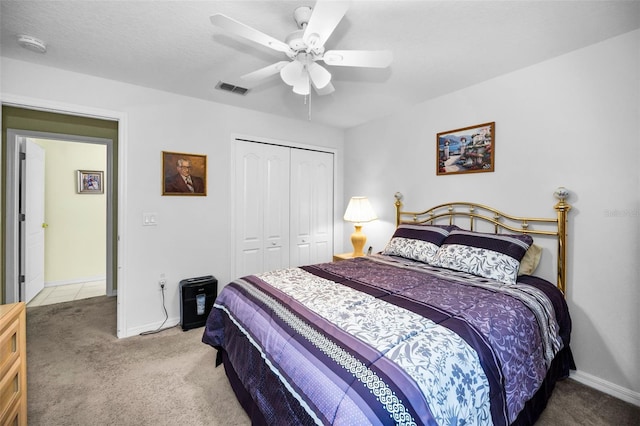 carpeted bedroom with ceiling fan and a closet