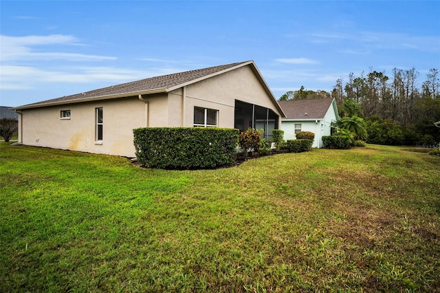 view of side of property with a yard and a sunroom